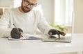 Businessman in compressive gloves work on computer write notes Royalty Free Stock Photo