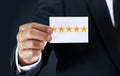 A businessman confident of success, he holds a white card with a rating of five stars or the highest