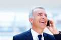 Businessman conversing on cell phone. Executive smiling and looking up while talking on cell phone. Royalty Free Stock Photo