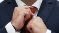 Businessman is Correcting Red Tie On A White Shirt