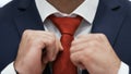 Businessman is Correcting Red Tie On A White Shirt