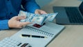 Businessman counting American dollars, income, and business concepts Man in blue T-shirt counting dollars and filling out financia Royalty Free Stock Photo