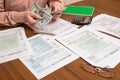 Businessman counting dollars of tax forms