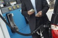 Businessman Counting Money At Fuel Station