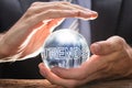 Businessman Covering Crystal Ball With Trends Text And Graphs