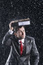 Businessman Covering Head With Binder In Rain