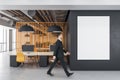 Businessman in coworking office interior with computers and blank banner on wall Royalty Free Stock Photo