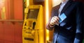 Businessman with credit card in hand, atm for cash withdrawal