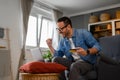 Businessman with credit card pumping fist and screaming in joy while doing online shopping on laptop Royalty Free Stock Photo