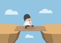 Businessman cross the cliff gap by wooden board as a bridge