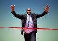 Businessman crossing finish line with arms up Royalty Free Stock Photo