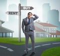 Businessman at crossroads betweem buying and renting Royalty Free Stock Photo
