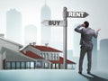 Businessman at crossroads betweem buying and renting Royalty Free Stock Photo