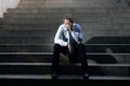 Businessman crying lost in depression sitting on street concrete stairs Royalty Free Stock Photo