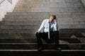 Businessman crying lost in depression sitting on street concrete stairs Royalty Free Stock Photo