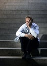 Businessman crying lost in depression sitting on street concrete stairs Royalty Free Stock Photo