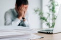 Businessman crying in the office, man covering face with hands and bursting in tears