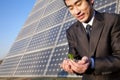 Businessman cupping plant in front of solar panel Royalty Free Stock Photo