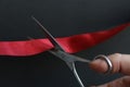 Businessman cuts ribbon with scissors