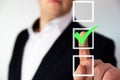 Businessman pushing checkbox button with a green tick.