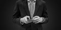 Businessman in dark blue suit using mobile smartphone, black and white