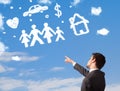 Businessman daydreaming with family and household clouds