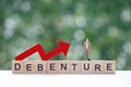 Businessman on debenture word with red arrow graph on natural green background, Investments and Debenture concept Royalty Free Stock Photo