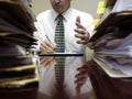 Businessman at Desk with Files Gesturing