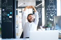 Businessman at the desk in his office stretching arms. Royalty Free Stock Photo