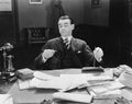 Businessman at desk looking at watch Royalty Free Stock Photo