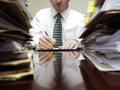 Businessman at Desk with Piles of Files