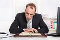 Businessman at desk with problems, stress and overworked sitting