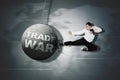 Businessman destroying a ball written Trade War