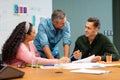 Businessman discussing business strategy with multiracial colleagues in meeting at creative office Royalty Free Stock Photo