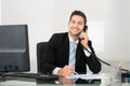 Businessman discussing over documents on telephone at desk Royalty Free Stock Photo