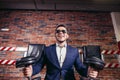 Businessman doing dumbbell biceps wearing formal suit. Royalty Free Stock Photo