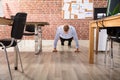 Businessman Doing Push Up In Office