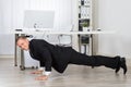 Businessman Doing Pushup At Work