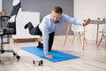 Businessman Doing Stretching Workout Using Smartphone App