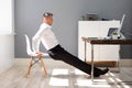 Businessman Doing Triceps Dips In Office