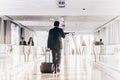 Businessman at airport corridor walking to departure gates.