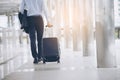 Businessman Dragging suitcase luggage,walking to passenger boarding in Airport.Asian tourist men wearing black suit with trolley Royalty Free Stock Photo