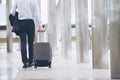 Businessman Dragging suitcase luggage,walking to passenger boarding in Airport.Asian tourist men wearing black suit with trolley Royalty Free Stock Photo