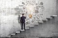 A businessman drawing a creative business strategy sketch on a concrete wall with steps in it Royalty Free Stock Photo