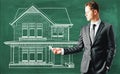 Businessman drawing house on chalkboard Royalty Free Stock Photo
