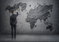 Businessman drawing world map on the concrete wall