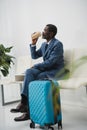 African american businessman drinking coffee while waiting for departure