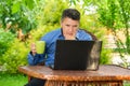 Businessman drinking coffee and reading news using laptop in his garden Royalty Free Stock Photo