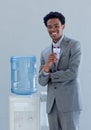 Businessman drinking from a water cooler in office Royalty Free Stock Photo