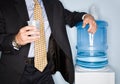 Businessman drinking water from water cooler